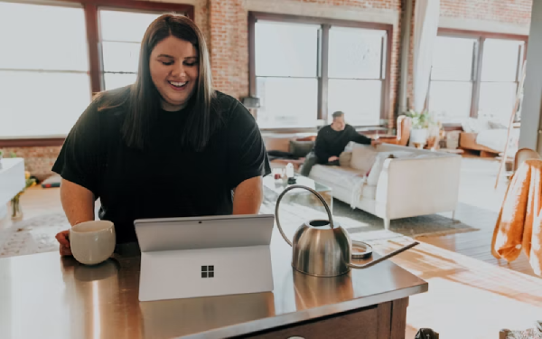 Woman working on a laptop in a bright home office space